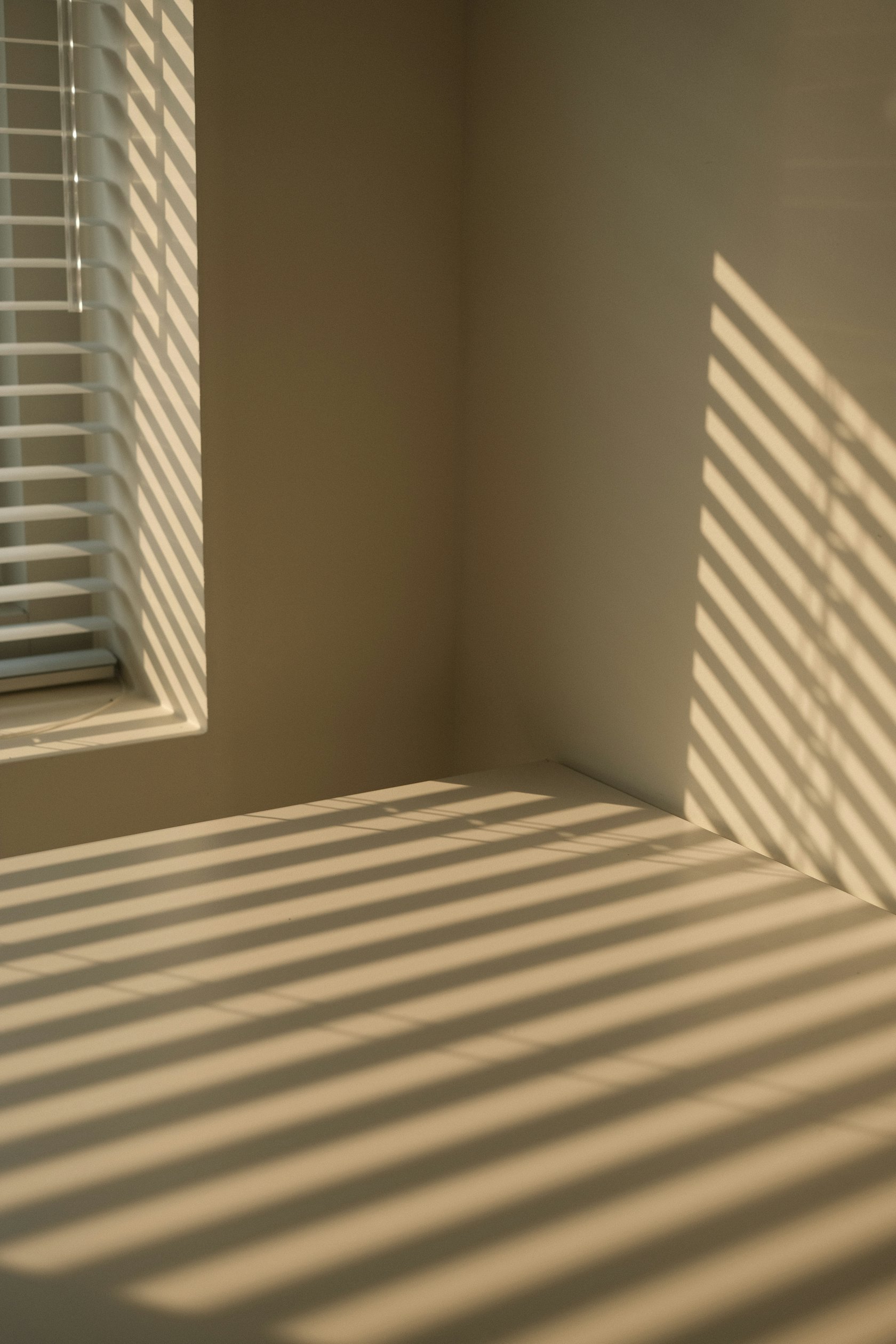 Lumière chaude filtrée par les volets dans un salon